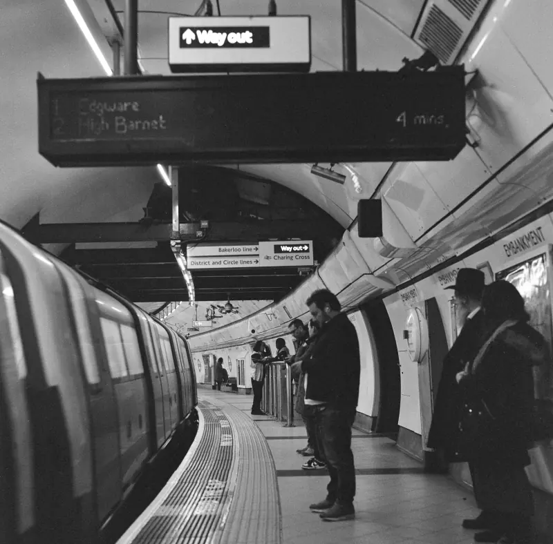 A group of people are waiting for a train at a subway station.