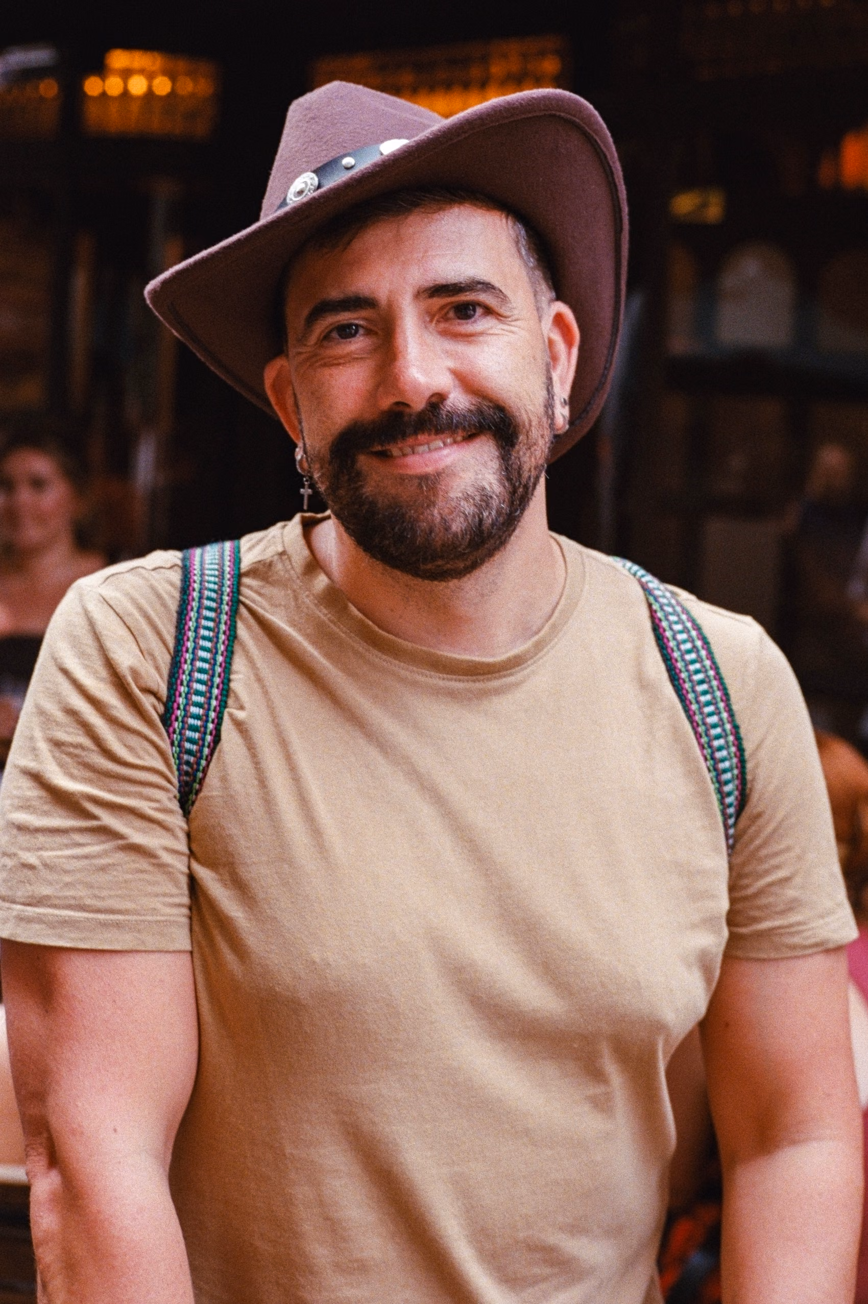 A man wearing a hat and a brown shirt.