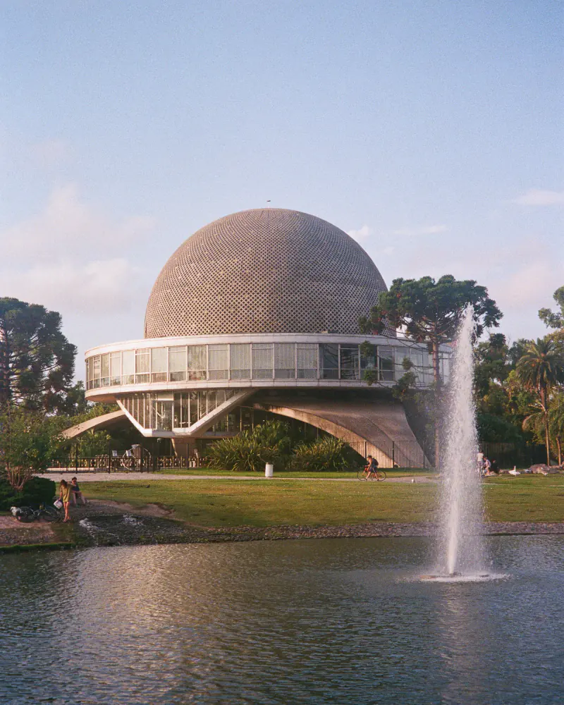 A large building with a water fountain in front of it.