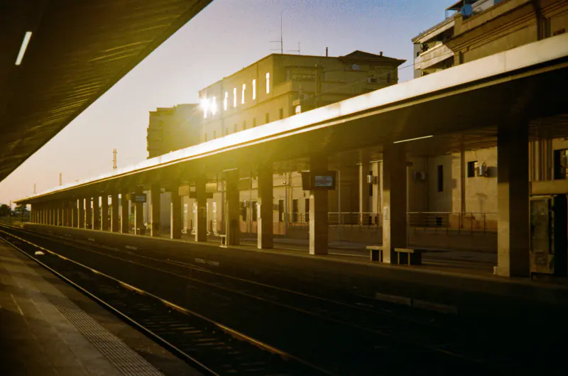 A train station with a train on the tracks.