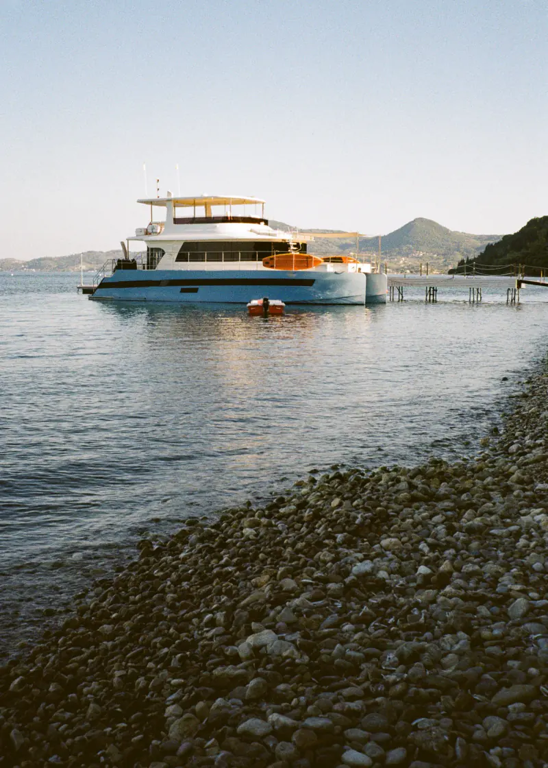 A blue boat is docked at a pier.