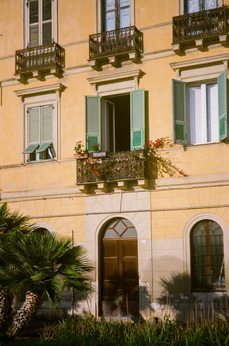 A building with a balcony and a window with a flower box.
