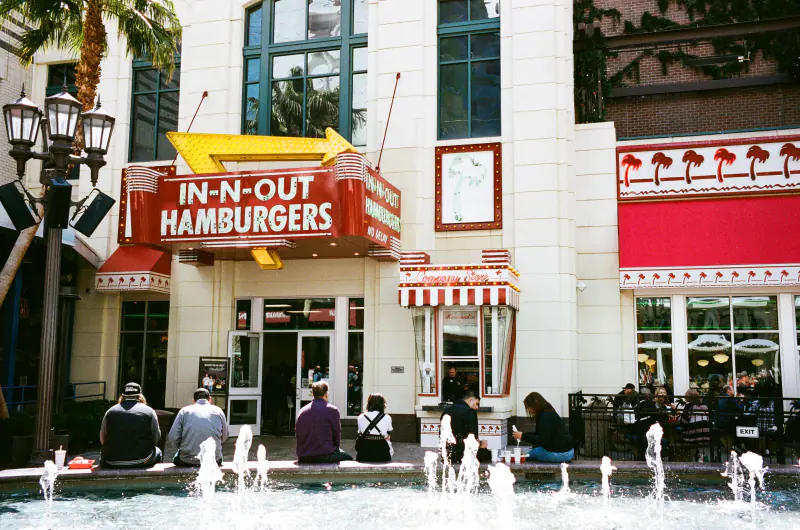 A group of people sitting outside of a restaurant.