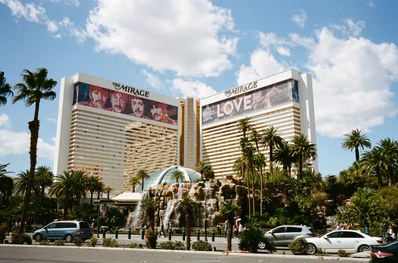 A large hotel with two towers and a fountain in front.