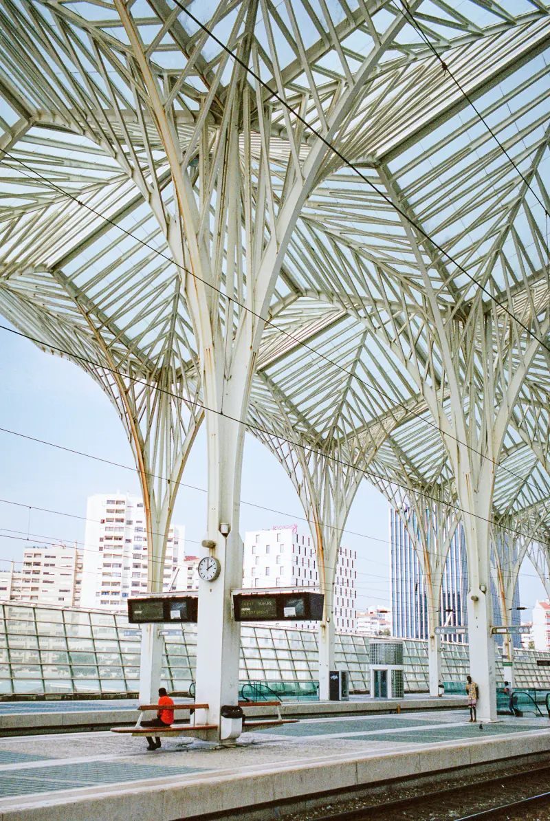 A train station with a clock and a metal roof.