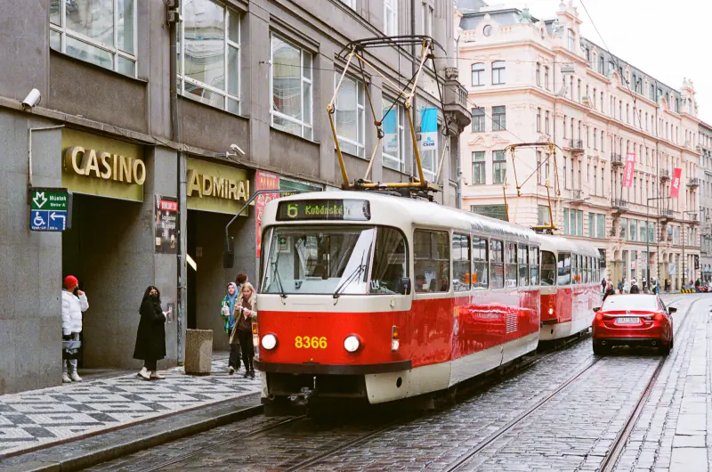 A red and white train is traveling down a street.