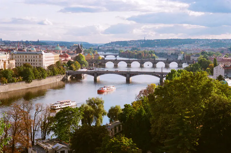 A city with a bridge over a river and a boat on the water.